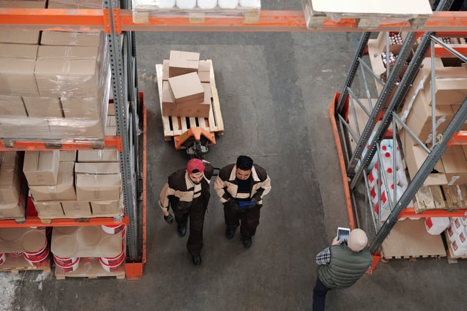 3 Men working in a shipment warehouse.