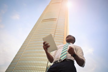 Successful businessman standing near high-rise building.