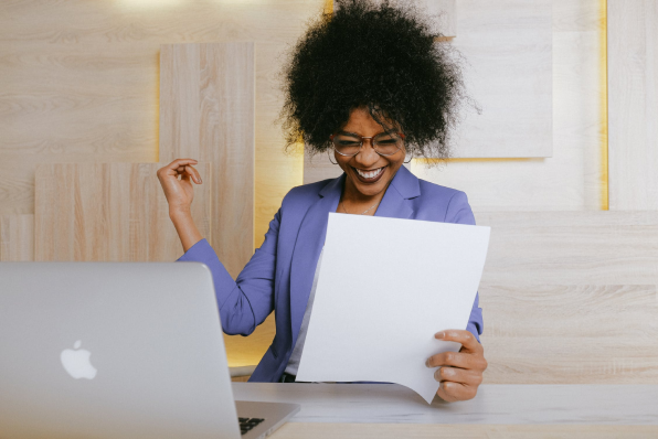 Happy woman looking at cost recovery on paper.
