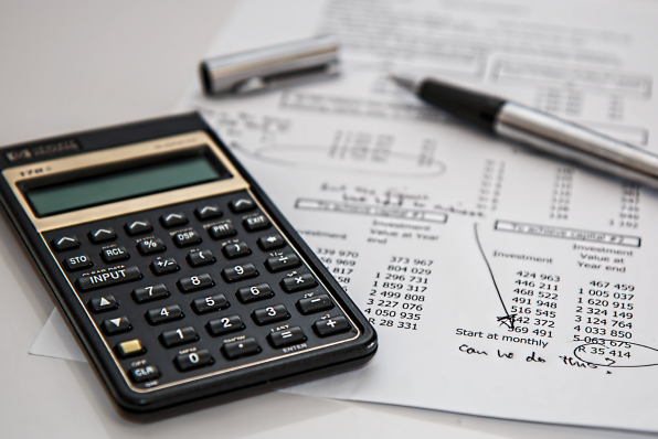 Black calculator near ballpoint pen on chargeback claim