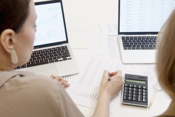 Two female accountants working out how to prevent Amazon deductions to their revenue.