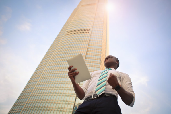 Successful businessman standing near high-rise building.
